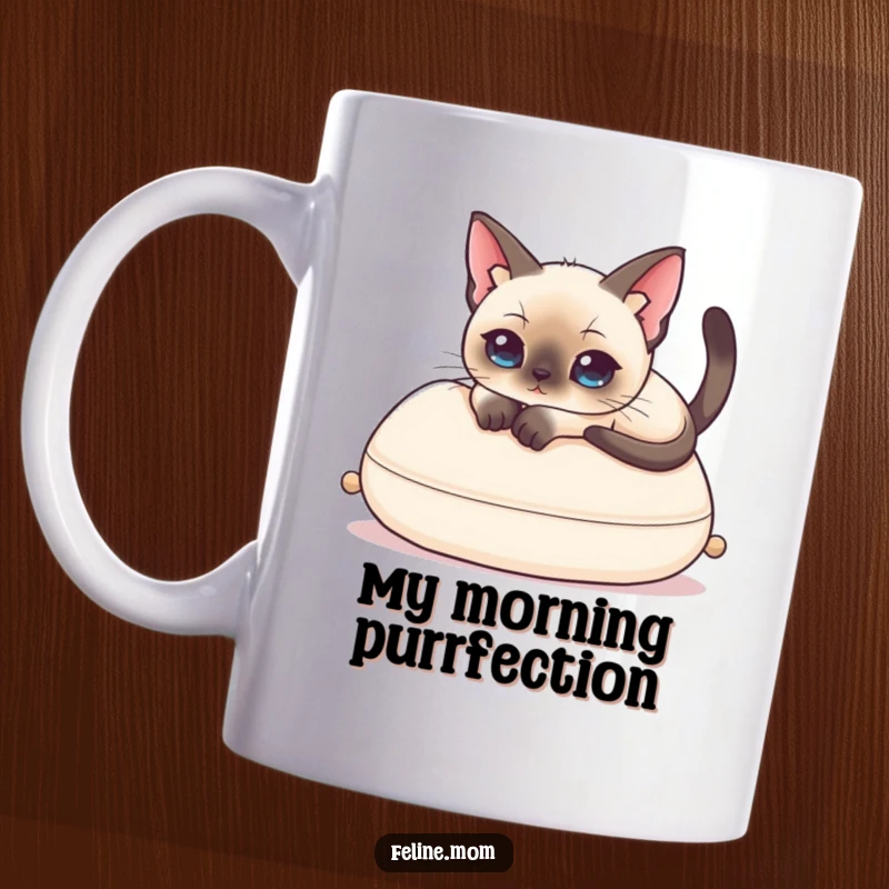 Funny Siamese Cat Mug showing an elegant cat lounging on a plush cushion, exuding regal laziness and a touch of humor.