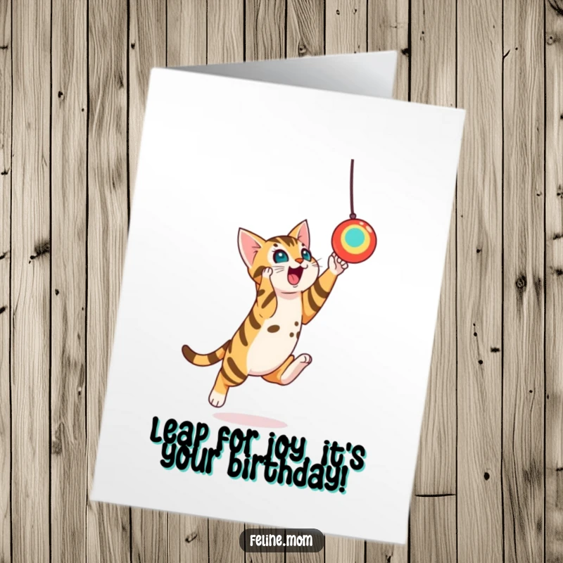 Funny Free Printable Birthday Card depicting a playful Bengal cat leaping dynamically towards a suspended toy, capturing pure energy for print at home.